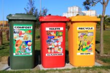 Waste boxes with posters showing principles of waste management and segregating waste according to plastic presence.