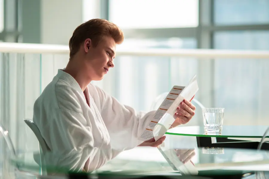 Man looking at a menu of a restaurant.