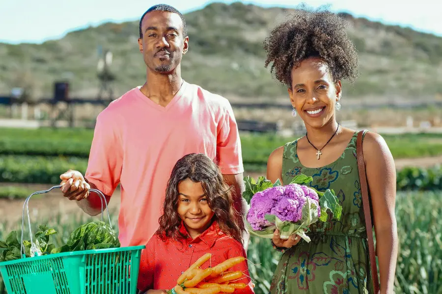 a family with the backdrop of  a farm.