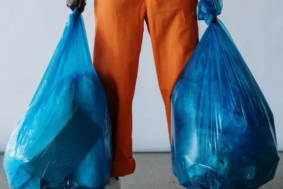 view of man holding two trashbags