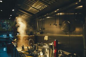 A food and beverage consultant reviewing menu engineering alongside commercial kitchen design to optimize workflow, operational efficiency, and restaurant profitability.