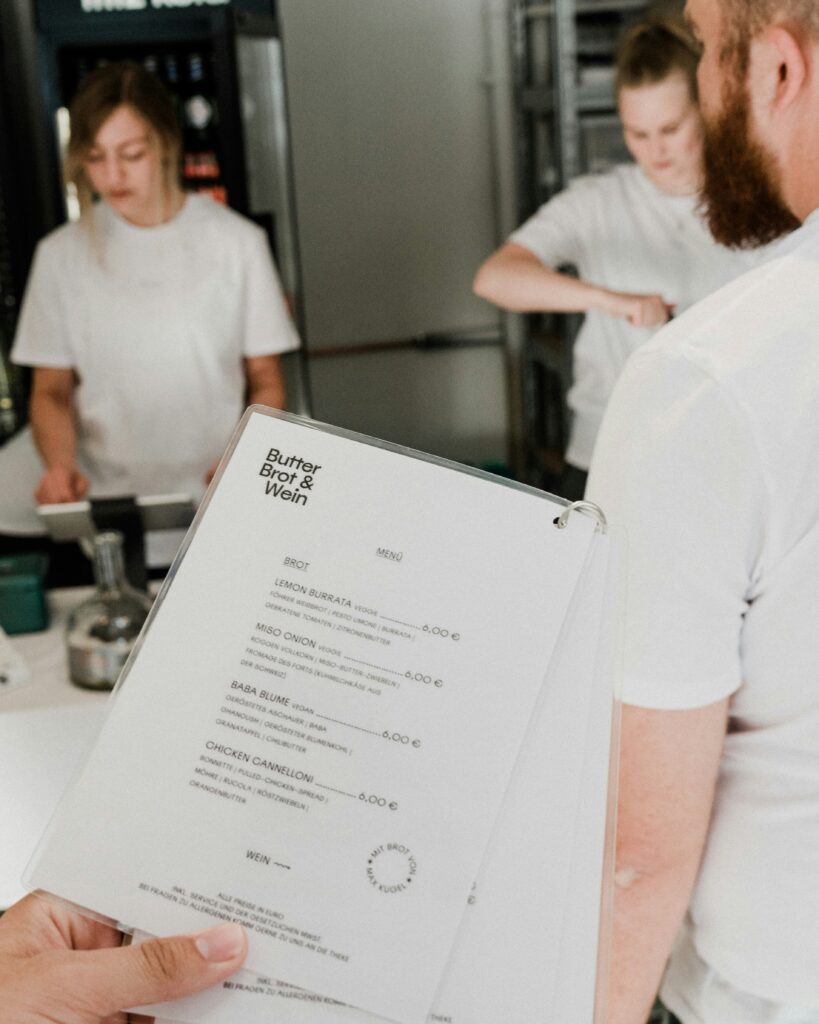 Food and beverage consultant reviewing menu design beside kitchen layout