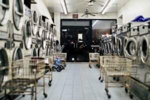 Hotel laundry room in active operation, illustrating hotel laundry design through steam management, space allocation and workflow sequence. Copy image description